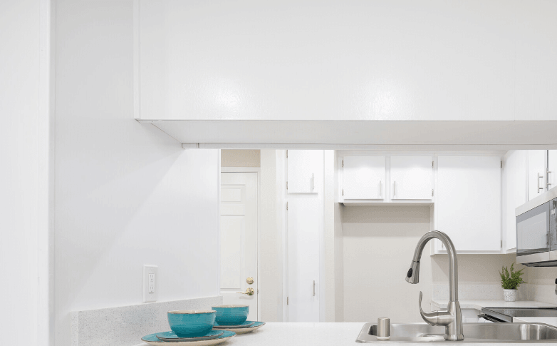 a white kitchen with a sink and a counter top a white kitchen with a sink and a counter top at Huntington Terrace North Senior, California